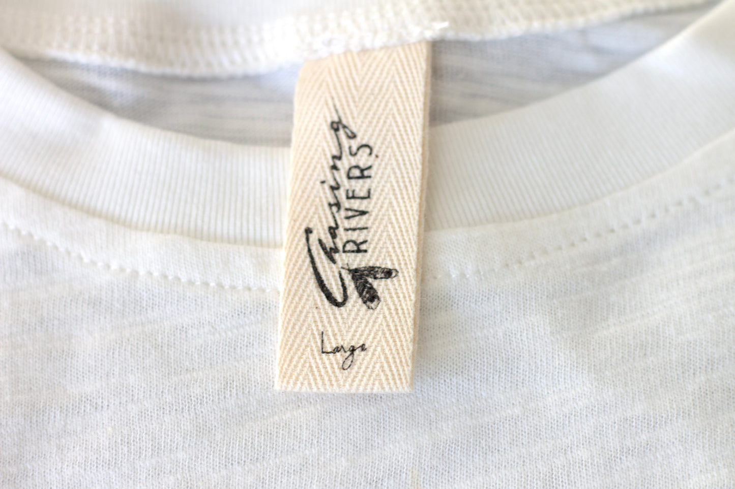 Close-up of the Chasing Rivers clothing label on an organic cotton t-shirt from the Studio Hannah Chloe collaboration.