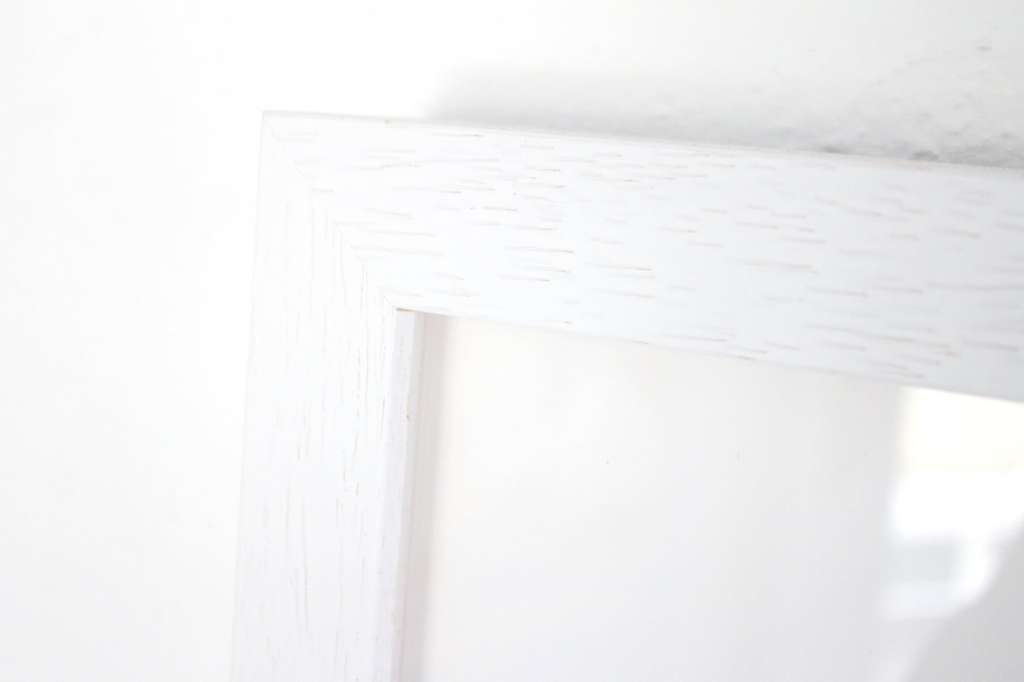 Close up detail of a white wooden box frame with a wood grain detail.