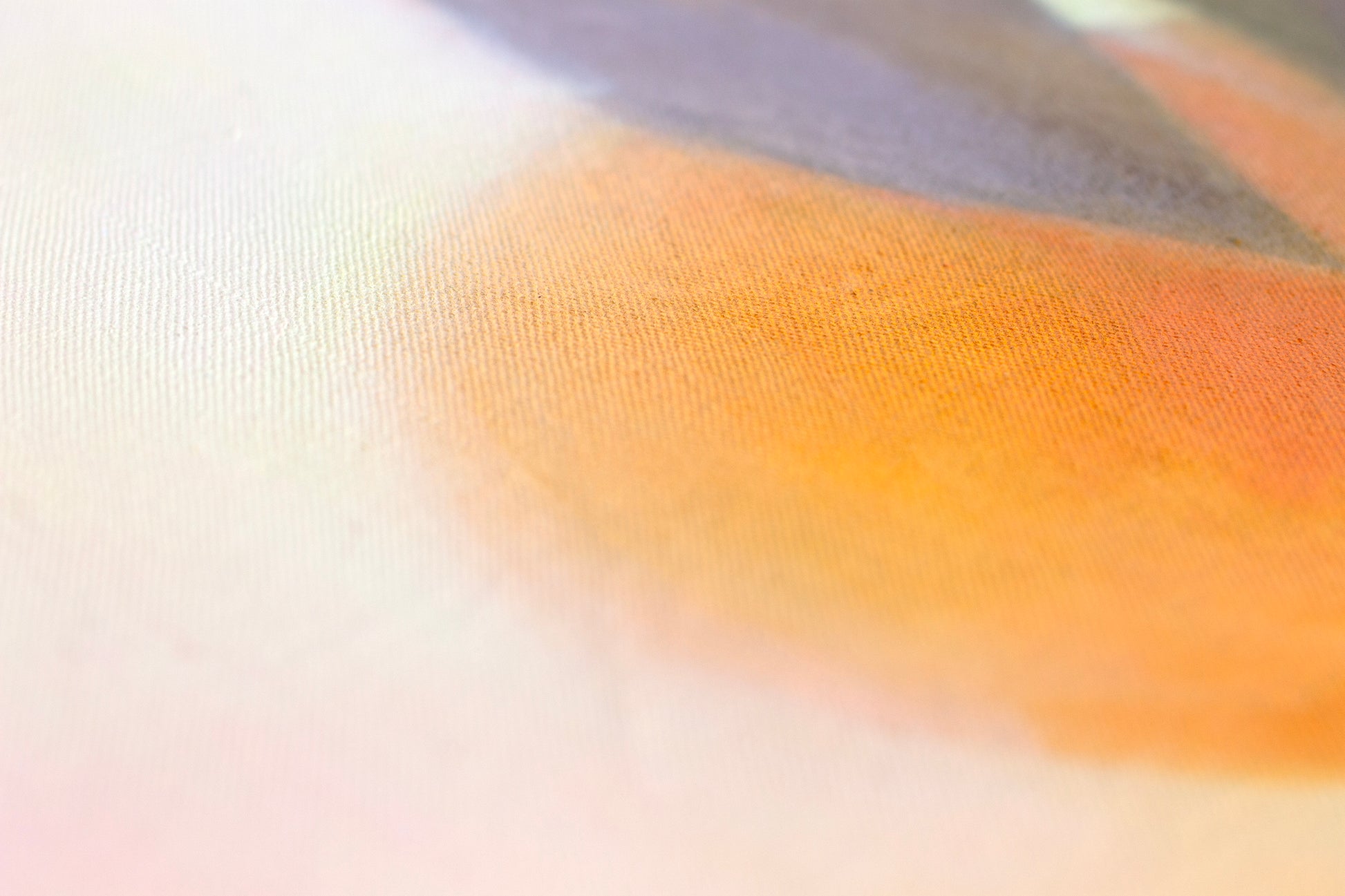 Close-up detail of orange painting showing textured canvas with soft citrus tones and blended warm colours.
