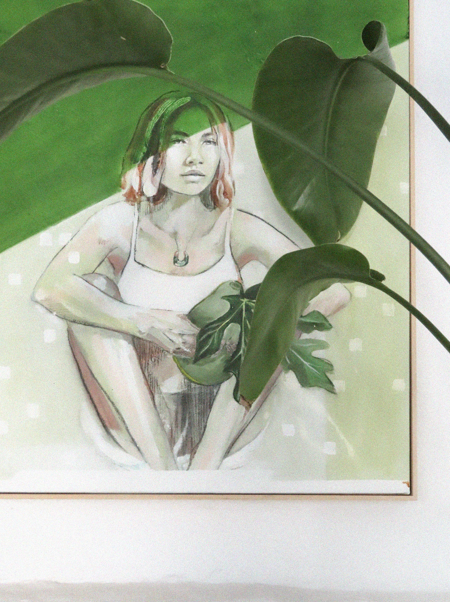 Portrait painting in green hanging with a plant as they merge together.
