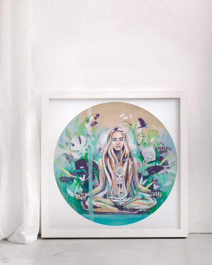 Yoga meditation print of a woman surrounded by green and turquoise. In a white frame in a white room.