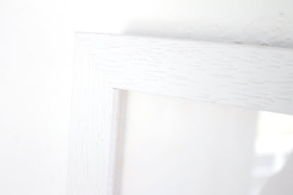 Close up detail of a white frame with woodgrain on a white background.