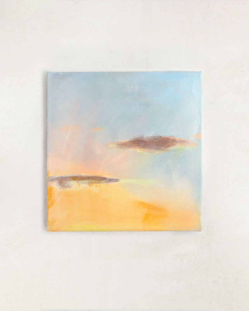 Sunset wall art with warm golden tones and soft blue sky, abstract landscape painting displayed in a neutral interior.