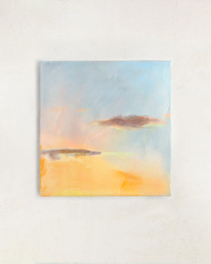 Sunset wall art with warm golden tones and soft blue sky, abstract landscape painting displayed in a neutral interior.