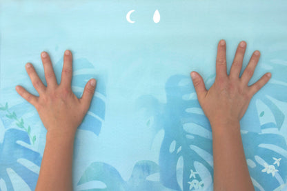 Two hands placed on a blue mat with nature-themed design