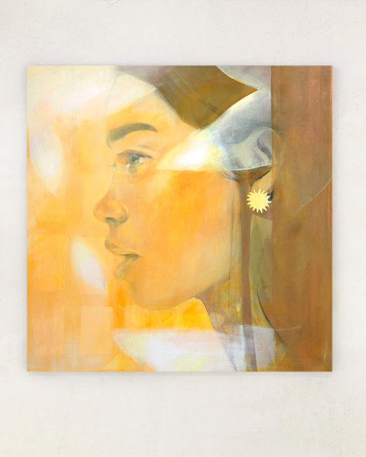 Orange portrait of a woman with leaf shadows on her face. Hanging on a white wall.