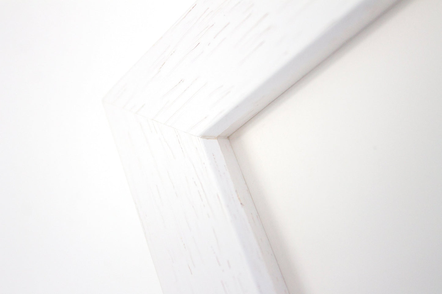 Close up detail of a white wood frame with grain detail.