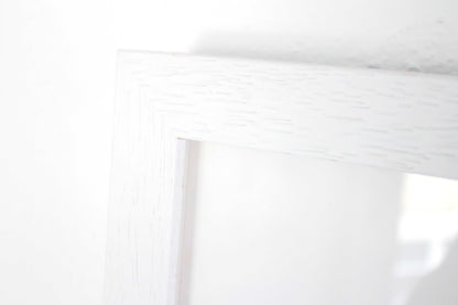 Close up detail of white box frame with wood grain.