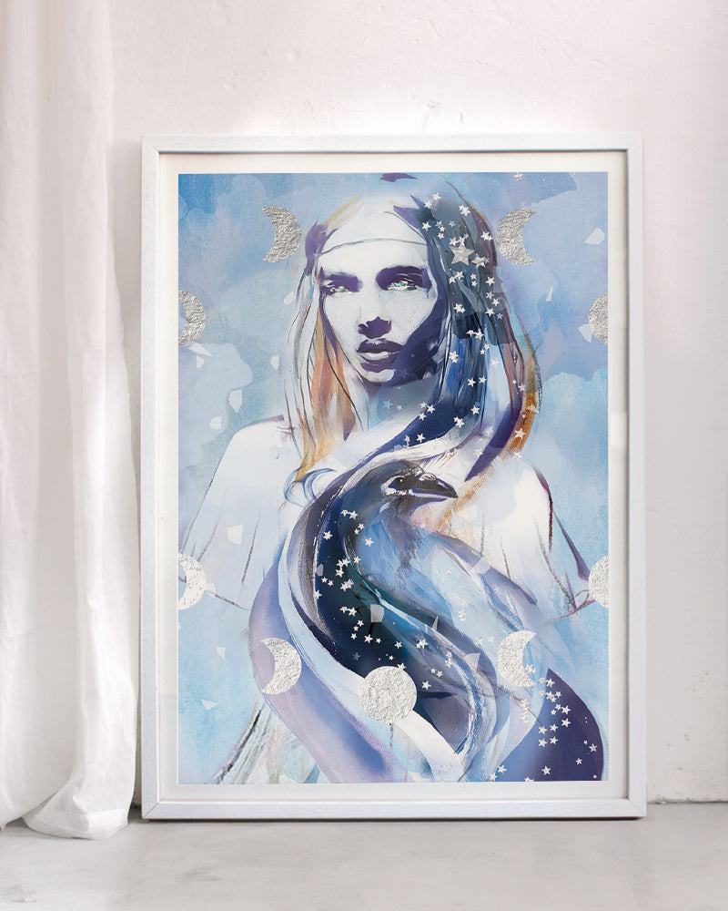 Framed art print titled Magic featuring a serene feminine figure intertwined with a bird, moon phases, and star patterns, painted in soft blue tones with silver leaf details, inspired by intuition and the air element.